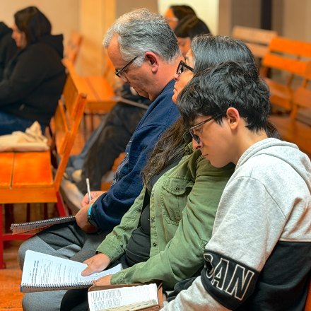 Familia estudiando la lección en la Escuela Dominical